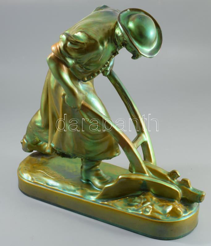 Zsolnay plasztika - Ekével szántó paraszt. Terv.: Pásztor János (1881-1945). cca 1900-1920, selyemfényű eozin mázakkal bevont öntött finomfajansz. Kis kopással, az eke fogója és a jobb váll restaurált, 41x40 cm. Csak pár darabban megvalósult formaterv!  ///  Az eozin többféle mázazási és égetési technika gyűjtőneve. Már évszázadok óta ismert díszítő eljárás, a Zsolnay gyár számára a 19. század végén Zsolnay Vilmos, Wartha Vince és Petrik Lajos dolgozta ki. E technika során a készülő tárgyakat egyre csökkenő hőfokon többször festik és égetik egymás után, elérve ezzel egy szivárványszerű, részben egymást átfedő, részben egymásba olvadó mázazást, melyet sok esetben végül savmaratással tesznek még dekoratívabbá.  ///  Zsolnay sculpture - Peasant ploughing with a plough. Design: János Pásztor (1881?-1945). Circa 1900-1920, cast fine faience covered with silky-sheen eosin glazes. Minor wear; the handle of the plough and the shoulder has been restored. Dimensions: 41 × 40 cm. This design was realized in only a few examples.  ///  Eosin is a collective term for several glazing and firing techniques. It has been known as a decorative process for centuries; for the Zsolnay factory it was developed at the end of the 19th century by Vilmos Zsolnay, Vince Wartha, and Lajos Petrik. During this decorative process, the objects are painted and fired repeatedly at progressively lower temperatures, resulting in a rainbow-like glazing with layers that partly overlap and partly merge into one another. In many cases, the surface is finally enhanced by acid etching to make it even more decorative.