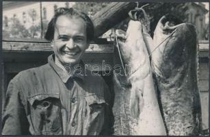 cca 1960 Egy elégedett horgász portréja, akinek napi zsákmánya két óriáshal, fotólap, 9x14 cm