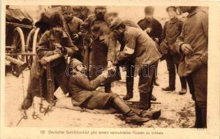 Deutscher Sanitätssoldat gibt einem verwundeten Russen zu trinken / German and injured Russian soldiers