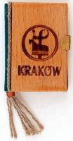 Kraków. 10 db fotó Krakkó nevezetességeiről, lengyelül feliratozva, minikönyv formátumú leporelló füzetben, fém kapoccsal, fa elő- és hátlappal