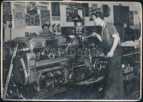 cca 1952 Tiszavölgyi József: Gépműhely, a háttérben politikai propaganda plakátok, pecséttel jelzett riportkép, felületén törésnyomokkal, 12x17 cm