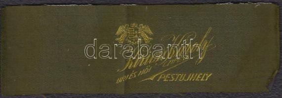 "Kiricsi Károly úri és női cipész, Pestújhely" feliratú szövetdarab, pajzstartós-koronás magyar kiscímerrel, 6×18 cm