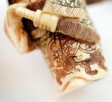 20. század. Necuke, forgatható két arccal, faragott, festett csontfigura, alján jelzett / m:4,5 cm
...