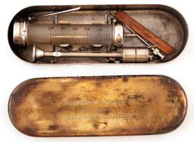 "Dr. Pápay-féle oltóanyagos szerum-intézet rt., Budapest VI. Teréz körút 31." feliratú fecskendőtartó fém doboz, lekopásokkal, benne fecskendővel