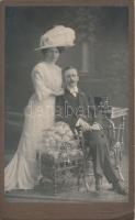 cca 1911 Kalapos hölgy, cilinderes úr, keményhátú fotó Schubernig budapesti műterméből, 21x13 cm