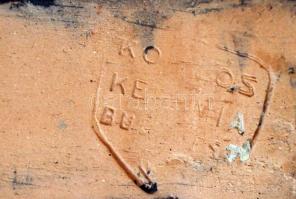 Komlós ülő kisfiú, mázas festett kerámia, jelzett, apró mázhibával, m:10 cm