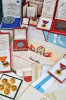 Szocialista jelvény, plakett és okirat tétel (legtöbb egymáshoz tartozó), összesen 14db jelvénnyel és plakettel, valamint 24 okirattal (igazolványok, adományozói iratok, oklevelek), közte a "Kisipari Szövetkezeti Mozgalom" és "Könnyűipar Kiváló Dolgozója" oklevelekkel T:vegyes