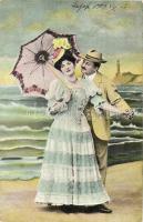 Couple on the shore, lady with an umbrella, lighthouse in the background (EK)