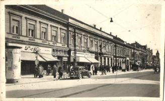 Újvidék, Novi Sad; utca részlet, Peko, Lukács Zsigmond, Obermiler üzletei, hirdetőoszlop, automobil, kerékpár, telefonfülke, Keller és Kiss kiadása / street view, shops, advertising column, automobile, bicycle, phone booth (fl)