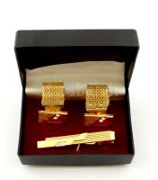 Arany színű fém mandzsetta pár és nyakkendőtű készlet, dobozban.