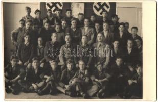 Third Reich-era school class, swastika flags in the background, photo
