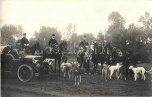 Hunters on horses with hunting dogs, mostly Sighthound dogs. Automobile, photo