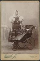 cca 1880-1900 Debrecen, Hölgy népviseletben, babkocsival, keményhátú műtermi fotó Németi műterméből, 12,5x8 cm