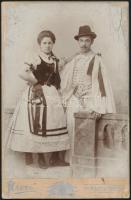 cca 1860-1890 Népviseletes pár, keményhátú fotó, Kecskemét, Fanto (Bernát), kopásnyomokkal, foltos, kissé sérült verzóval, 16x10 cm.