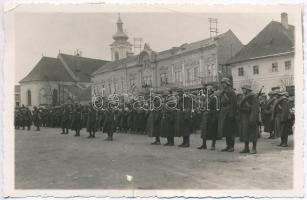 1940 Kézdivásárhely, Targu Secuiesc; bevonulás, katonák sorfala, háttérben Bándy István üzlete és gyógyszertár. Lénárd fényképész / entry of the Hungarian troops, photo (szakadás / tear)