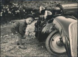 Jelzés nélkül: cca 1940 Autót kurblizó gyermek. Vintage fotó. 18x13 cm