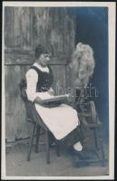 cca 1930 Népviseletes lány a rokkánál, fotólap, 14×9 cm