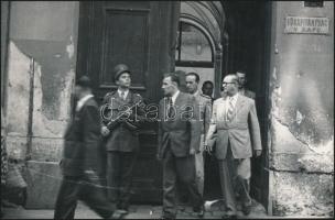 1948 Kádár János (1912-1989) belügyminiszterként és Münnich Ferenc (1886-1967) rendőrfőkapitányként elhagyják a rendőrség épületét, hátoldalon feliratozott fotó, 12x18 cm