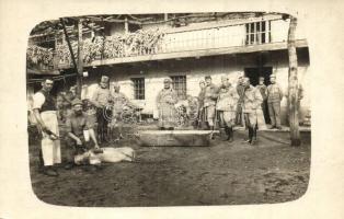 Első világháborús osztrák-magyar katonai lap. Disznóölés egy elfoglalt gazdasági épületben / WWI K.u.K. military, soldiers slaughtering a pig in the courtyard of an occupied farm. photo