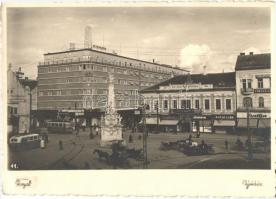 Újvidék, Novi Sad; Szabadság tér, Szentháromság szobor, villamossal és autóbusszal. Astra üzlet és más boltok, mozi plakátok / Liberty Square with tram and autobus, statue, shops and cinema posters. Royal Foto Studio