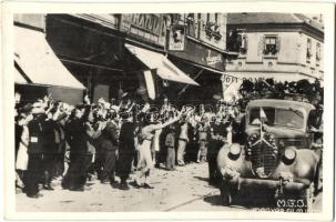1940 Nagyvárad, Oradea; bevonulás, csendőrök automobilon, ünneplő tömeg, magyar zászló, üzletek / entry of the Hungarian troops, Hungarian flag, cheering crowd, shops
