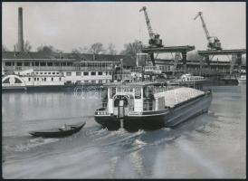 1965 MHRT 100 tonnás, 2 hajtással felszerelt toló-önjáró dereglye, mögötte a Felszabadulás hajóval, darukkal, retusált, feliratozott sajtófotó, egyik sarkán törésnyommal, 13×17,5 cm