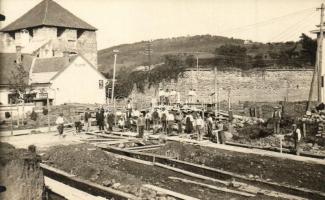 ~1910 Korpona, Krupina; Az 1945-ben lerombolt Várkapu mögötti tér, ház alapozása építkezéskor, munkások csoportképe. Háttérben Kiss Géza szabó üzlete és a Földműves Kölcsönös Pénztár épülete / Krajcír, Rolnícka Vzájomná Pokladnica / square behind the castle gate (demolished in 1945), construction of a house priming with workers. Tailors shop and agricultural bank in the background - 2 db eredeti fotó képeslap / 2 original photo postcards