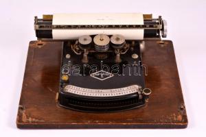 Frolio 5 régi kisméretű írógép, fém védőburkolatán horpadásokkal, 23×30 cm