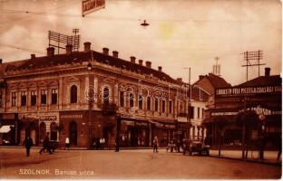 1931 Szolnok, Baross utca, Lassan hajts tábla, gyógyszertár, Kinolovits Bazár, Stühmer Cukorka, borbély és fodrász, Enyedi András húscsarnoka, Dohánytőzsde, Váczy Mihály, Fehér Irén, Gerő Ignácz, Gaál Imre és Lendvai József üzlete, Lábassy-féle mezőgazdasági ipar és gépgyártó rt., Shell benzinkút, Jásznagykun-Szolnok megyei Ford autó rt., automobil