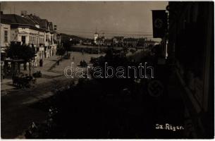 1940 Szászrégen, Reghin; bevonulás, üzletek, horogkeresztes zászlók, utcai benzintöltő állomás / entry of the Hungarian troops, street view, shops, swastika flags, gas filling station. photo