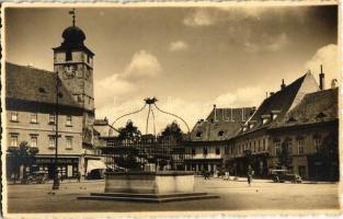 Nagyszeben, Hermannstadt, Sibiu; Piata Regele Ferdinand cu fantana istorica / Grosser Ring mit historischem Brunnen anno 1798 / Ferdinánd király tér, kút, Mathias Schoger üzlete, automobilok / square with historical fountain, shops and automobiles. Foto E. Fischer