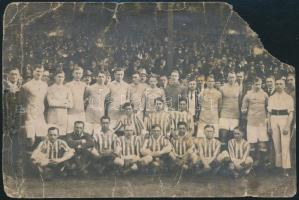 1921 A Ferencváros labdarúgó csapata és a göteborgi Kamraterna csapata az 1921. márciusi Húsvéti Tornán vívott meccse utáni csoportképen (FTC győzött 1:0-ra) a Hungária úton, hátoldalon feliratozott fotó (FTC: Csajka, Wiener, Hungler II., Szabó, Obitz, Tóth Potya, Schwartz, Kertész, Nikolsburger, Wiener II), hátoldalon feliratozott, hiányos, sérült fotólap, 8×12 cm