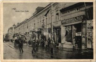 Iasi, Jassy, Jászvásár (Moldva, Moldova); Strada Cuza-Voda, H. Goldsteins La Fortuna, La Ghemul Ros , Traina / street view with shop and Romanian flags (EK)