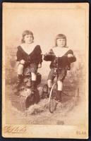 cca 1900 Két gyerek portréja, az egyik kerékpárral, keményhátú fotó, Bad Neudorf, Stöhr műterméből, 15x10 cm.
