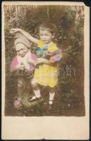 cca 1930 Kisgyermek törpével, színezett fotólap (Wellington), egyik sarkán kis hiány, 14×9 cm