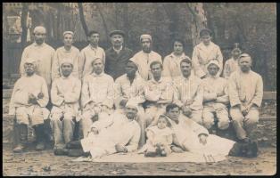 cca 1910-1920 Ápolók és ápoltak, fekete bőrű emberrel a csoportképen, fotólap, hátul pecséttel jelzett, 9x14 cm