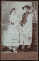 cca 1900 Szép népviseletben fotózkodó ifjú pár, fotó Dékány Jenő karcagi fényképész műterméből, 16×10 cm