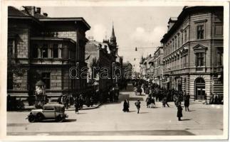 Szabadka, Subotica; utcakép, automobil, üzletek, háttérben a városháza / street view, automobile, shops, town hall + "1941 Szabadka visszatért" So. Stpl.