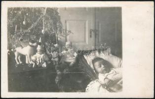 cca 1920 Kisbaba karácsonyi játékai, ajándékai, fotólap, 8,5×13,5 cm