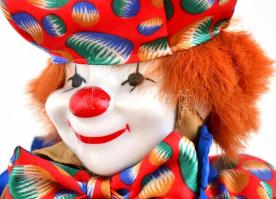 Bohóc ruhában, porcelán fejjel és végtagokkal. Zenélő funkcióval, mely közben felsőtestét és fejét m...