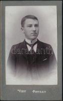 cca 1910 Fiatal férfi műtermi portréja, keményhátú fotó Lenics Géza nagyszalontai műterméből, szecessziós hátlappal, 10,5×6,5 cm