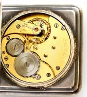 Ezüst (Ag) Omega zsebóra négyszögletes, illusztrált tokkal. Jelzett, működő állapotban, fém óraláncc...