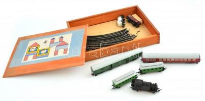 Vasúti műanyag modell játék tétel fa dobozban: 12 db sín, 1 db mozdony, 6 db vagon. Egyik sín deformált és hiányos, máskülönben jó állapotban.