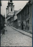 cca 1960 Székesfehérvár, utcakép, golyó ütötte ház falával, fotó, 17×12 cm