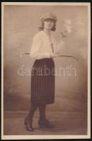 cca 1920 Divatos fiatal hölgy cigarettával, jelzés nélküli vintage fotó, kasírozva, 20,4x13,1 cm