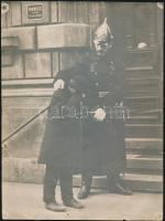 cca 1930 Budapest, rendőr fülön csípett gyerekkel, fotó, szakadással, 24×17,5 cm