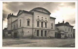 Munkács, Mukacheve, Mukacevo; a városi színház az 1939. évi január hó 6-iki cseh orvtámadás jelével, üzletek. Schönfeld Henrik kiadása / theatre damaged by a Czech attack, shops