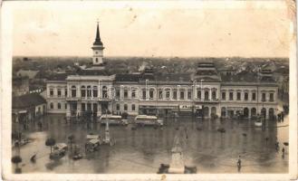 Óbecse, Stari Becej; községháza, Szent István tér eső után, MÁVAUT autóbuszok, Hubet Izidor, Janek Testvérek, Bata cipő és fodrászterem üzlete, piaci bódék. Hungária nyomda kiadása / town hall, square after rain, shops, autobuses, market stalls (EB)