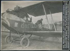 1914-1918 Osztrák-magyar katonai repülőgépből kirakodják a légipostát Bécsben, a Bécs-Budapest közötti rendszeres járaton, sajtófotó, német nyelvű felirattal, K.u.K. Kriegspressequartier, Lichtbildstelle Wien bélyegzéssel, 12,5x17 cm / 1914-18 Austro-Hungarian mail plane transporting air mail from Budapest to Vienna (Wien) with the regular flight organised by the army, unloading after landing in Vienna, with description in German languague at the top, with K.u.K. Kriegspressequartier, Lichtbildstelle Wien stamp on the reverse, photo, 12,5x17 cm