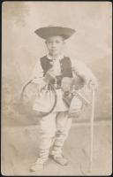 1911 Pipázó drótostótnak öltözött kisfiú, dicsőszentmártoni fotólap, hátulján feliratozott, 14x9 cm